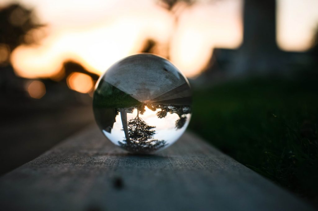 A Lensball containing an image of a tree with the sunset in the background